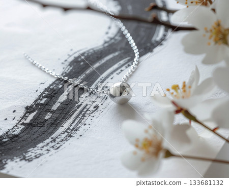 一條銀項鍊在抽象墨蹟的襯托下熠熠生輝——現代日式極簡主義設計,以其優美的留白令人著迷。 一條銀項鍊在抽象墨蹟的襯托下熠熠生輝——現代日式極簡主義設計,以其優美的留白令人著迷。 133681132