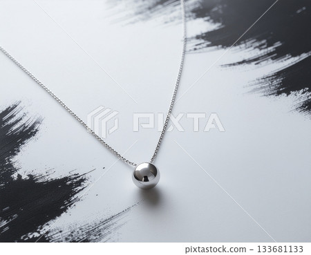 一條銀項鍊在抽象墨蹟的襯托下熠熠生輝——現代日式極簡主義設計,以其優美的留白令人著迷。 一條銀項鍊在抽象墨蹟的襯托下熠熠生輝——現代日式極簡主義設計,以其優美的留白令人著迷。 133681133