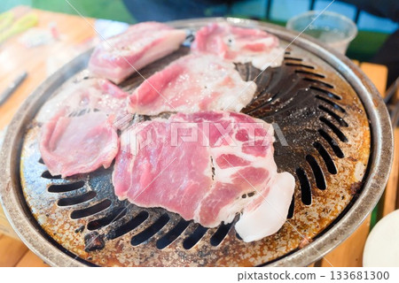 Pork slices being grilled in a Genghis Khan pot (outdoor cooking) Pork slices being grilled in a Genghis Khan pot (outdoor cooking) 133681300