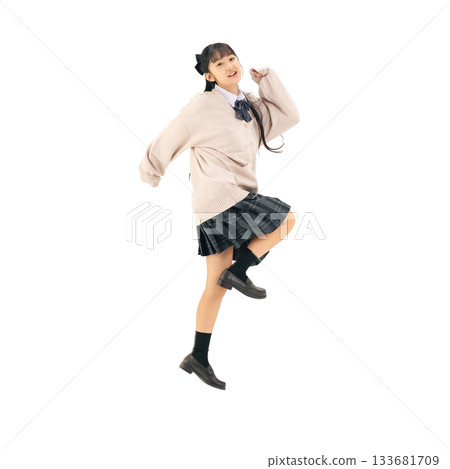 A female student in a uniform jumping energetically. A transparent, hand-cut, full-body PNG photo. 133681709