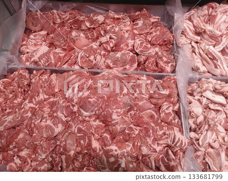 Thin sliced raw pork piled in meat counter with marbled fat and fresh texture, appetizing display of butcher shop selection 133681799