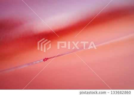 Closeup of red car with paint damage, long scratch 133682860