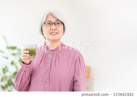 老年女性飲用綠汁、綠色冰沙和蔬菜汁有益健康 老年女性飲用綠汁、綠色冰沙和蔬菜汁有益健康 133682882