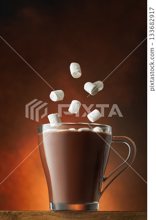 Marshmallows falling into cup of hot chocolate on brown background 133682917
