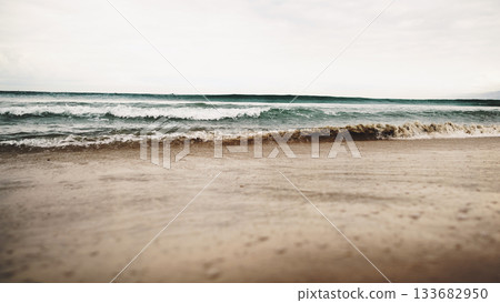 ocean waves on beach in cloudy day 133682950