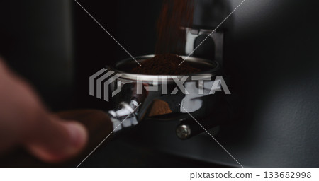 Grinding coffee into naked portafilter 133682998