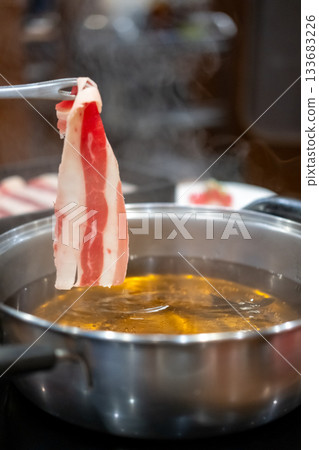 Chopstick holding sliced meat. hot pot 133683226