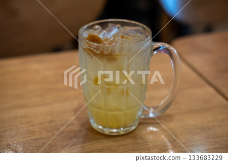A glass of plum soda, on the wooden table 133683229