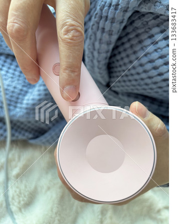 Close up of a modern pink hair dryer, beauty styling device for home hair care, detailed view of personal grooming equipment, professional blow dryer technology Close up of a modern pink hair dryer, beauty styling device for home hair care, detailed view of personal grooming equipment, professional blow dryer technology 133683417