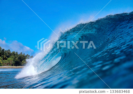 Energetic surf soaring over coral reef with dazzling sunlight reflections Energetic surf soaring over coral reef with dazzling sunlight reflections 133683468