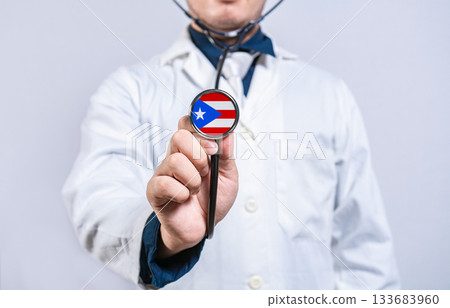 Healthcare worker holding stethoscope with Puerto Rico flag. Puerto Rico health and care concept 133683960