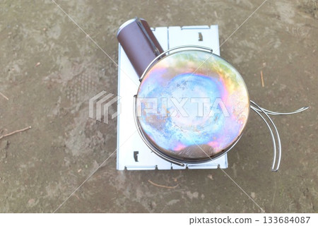 A shot of the browning of the bottom of a titanium pot and the gear of an outdoor burner 133684087