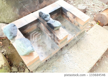 Outdoor facilities include a brick stove and bonfire remains. 133684546