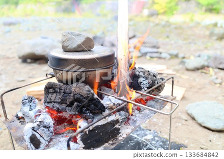 Outdoor cooking scene with mess tin rice cooker and campfire cooking Outdoor cooking scene with mess tin rice cooker and campfire cooking 133684842