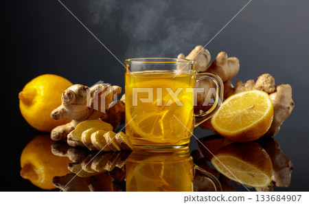 Ginger tea with lemon on a black background. 133684907