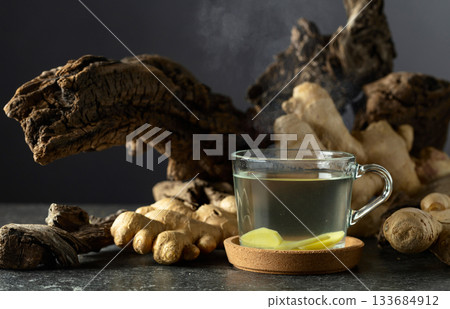 Ginger tea with old snags on a black background. 133684912