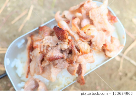 Pork belly on rice cooked in a mess tin 133684963