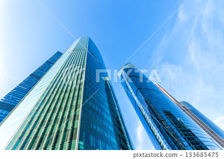 Modern glass skyscrapers on a clear day. Business center of a big city Modern glass skyscrapers on a clear day. Business center of a big city 133685475