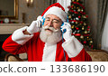 Santa Claus enjoys music with headphones on Christmas Eve 133686190