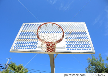 我拍了一張在藍天映襯下閃閃發光的籃球架的照片。 133686267