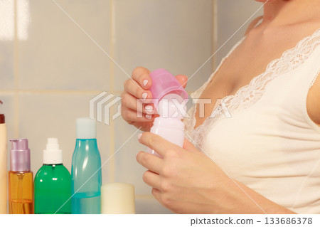Woman holds stick deodorant cosmetic in hands 133686378