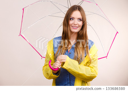 Woman wearing waterproof coat under umbrella Woman wearing waterproof coat under umbrella 133686380