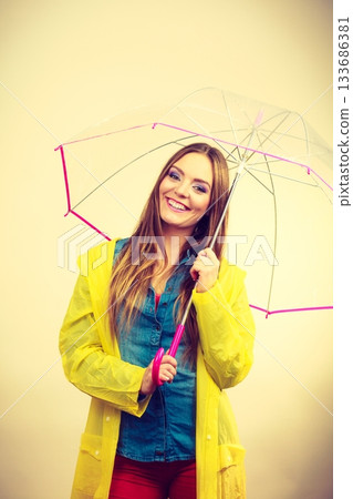 Woman wearing waterproof coat under umbrella Woman wearing waterproof coat under umbrella 133686381