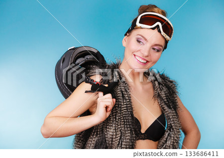 Woman seductive girl in ski googles holds helmet 133686411