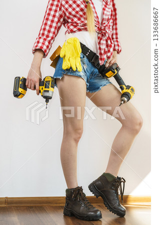 Woman with toolbelt and drill 133686667