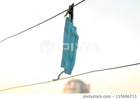 Disposable Face Mask Hanging on a Clothesline 133686713