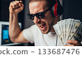 Excited man celebrates financial success, holding cash and wearing sunglasses 133687476