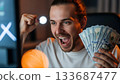Excited man celebrating a financial win while holding a wad of cash 133687477