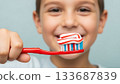 happy child with a red toothbrush and toothpaste ready to brush teeth 133687839