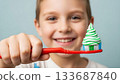 Smiling boy holding a toothbrush with toothpaste shaped like a Christmas tree 133687840