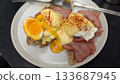 A plate of Eggs Benedict with runny yolk on the toast and bacon 133687945