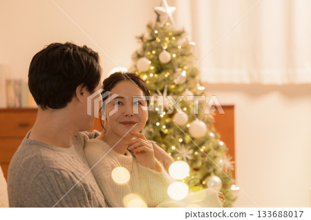 Smiling couple on winter date in front of the Christmas tree 133688017