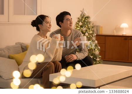 一對可愛的情侶在房間裡享受時光,房間裡亮著類似夜晚白熾燈的黃色燈光,擺放著聖誕樹,營造出冬風氛圍。電視和其他媒體也出現在畫面中。 一對可愛的情侶在房間裡享受時光,房間裡亮著類似夜晚白熾燈的黃色燈光,擺放著聖誕樹,營造出冬風氛圍。電視和其他媒體也出現在畫面中。 133688024