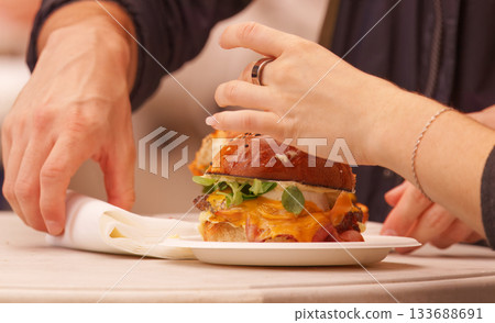 Couple enjoying gourmet burgers at Prague food festival Couple enjoying gourmet burgers at Prague food festival 133688691