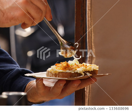 Close-up of hands preparing open sandwich with spread Close-up of hands preparing open sandwich with spread 133688696