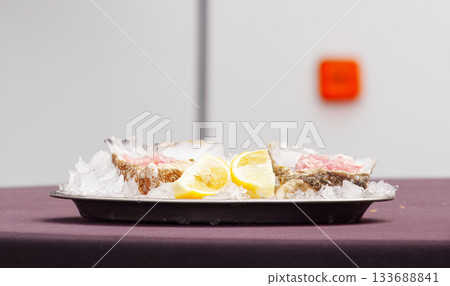 Fresh oysters on ice with lemon slices Fresh oysters on ice with lemon slices 133688841