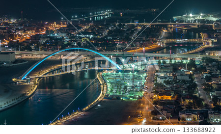 Dubai water canal with footbridge aerial night timelapse from Downtown skyscrapers rooftop 133688922