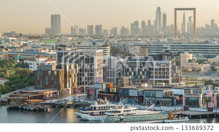 Dubai creek landscape timelapse with boats and ship near waterfront and modern buildings in the background during sunset Dubai creek landscape timelapse with boats and ship near waterfront and modern buildings in the background during sunset 133689372