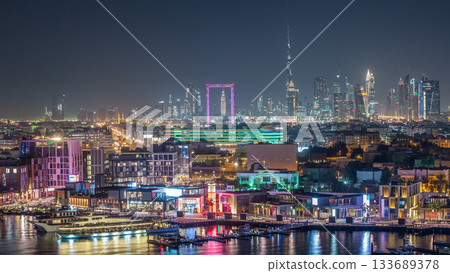Dubai creek landscape night timelapse with boats and ship near waterfront 133689378