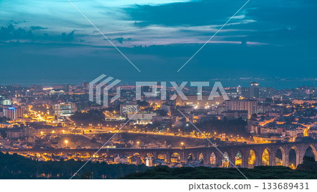 Panoramic view over Lisbon and Almada from a viewpoint in Monsanto night to day timelapse. 133689431