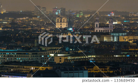 Aerial panorama above houses rooftops in a Paris night timelapse 133689450