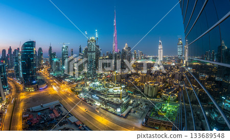 Dubai Downtown day to night timelapse. Aerial view over big futuristic city by night. Dubai Downtown day to night timelapse. Aerial view over big futuristic city by night. 133689548