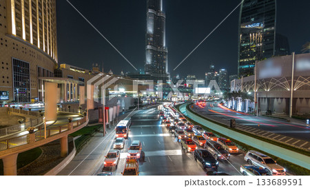 Car traffic on road near mall at night in downtown timelapse hyperlapse. 133689591