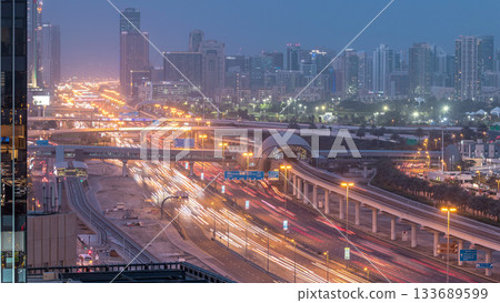 Aerial view of Jumeirah lakes towers skyscrapers day to night timelapse with traffic on sheikh zayed road. 133689599
