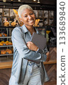 African American woman with short blond hair smiles and holds laptop in her hands.  133689840