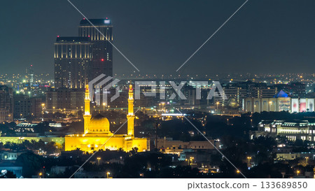 Dubai skyline with The Jumeirah Mosque illuminated at night timelapse. Dubai, United Arab Emirates 133689850